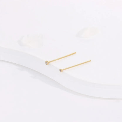 Minimalist gold stud earrings with small clear stones on white background, Rosary Milano jewelry