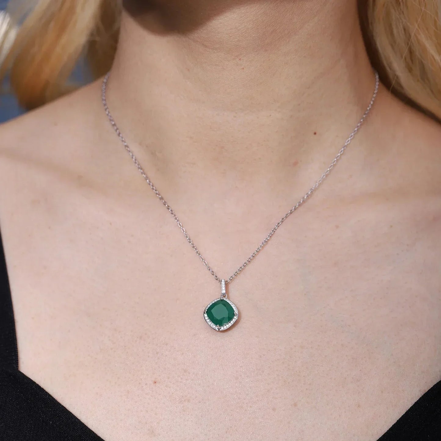 Woman wearing RosaryMilano silver necklace with green gemstone pendant on bare neckline