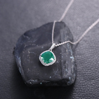 Emerald pendant necklace with silver chain displayed on black stone, Rosary Milano jewelry