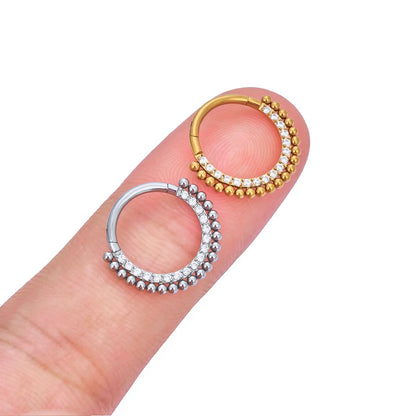 Gold and silver beaded hoop earrings with crystals from Rosary Milano on fingertip