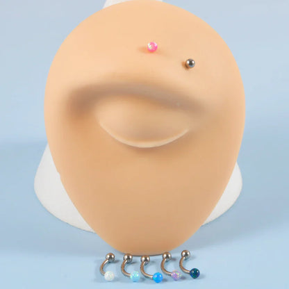 Barbell eyebrow piercing with opal titanium curved barbell