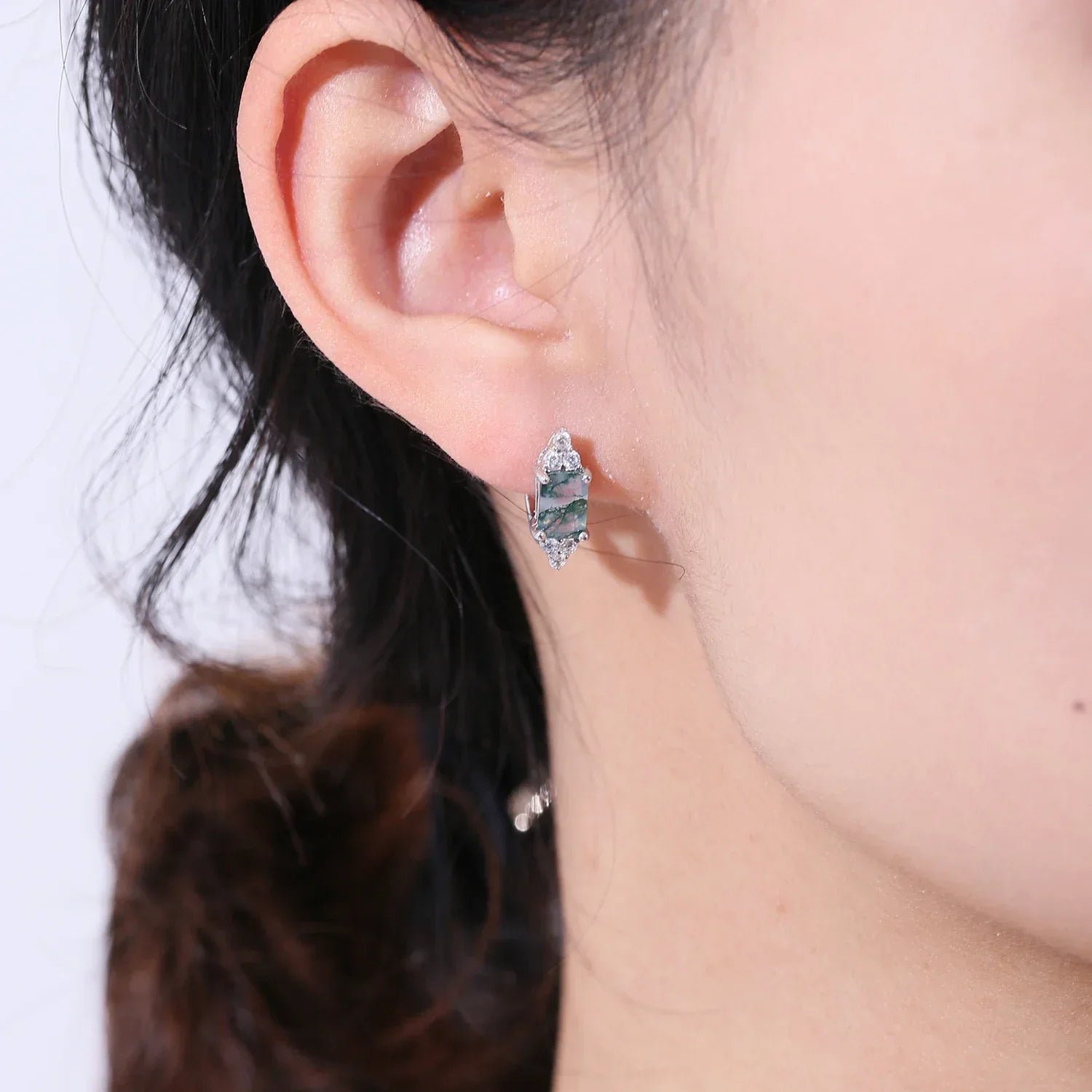 Woman wearing Rosary Milano green gemstone stud earring, close-up on ear