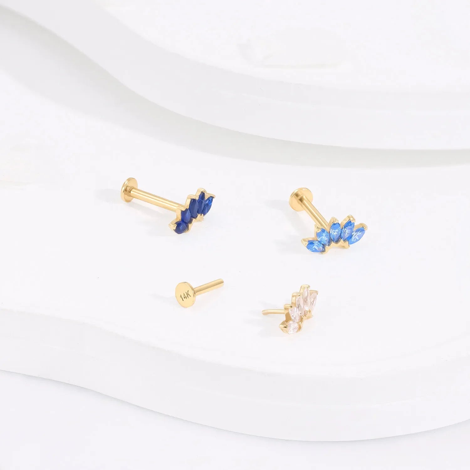 Rosary Milano gold earrings with blue and clear gemstones on a white background