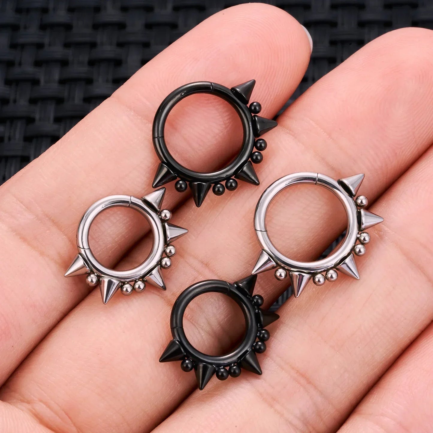 Black and silver spiked hoop earrings on hand, RosaryMilano fashion jewelry.