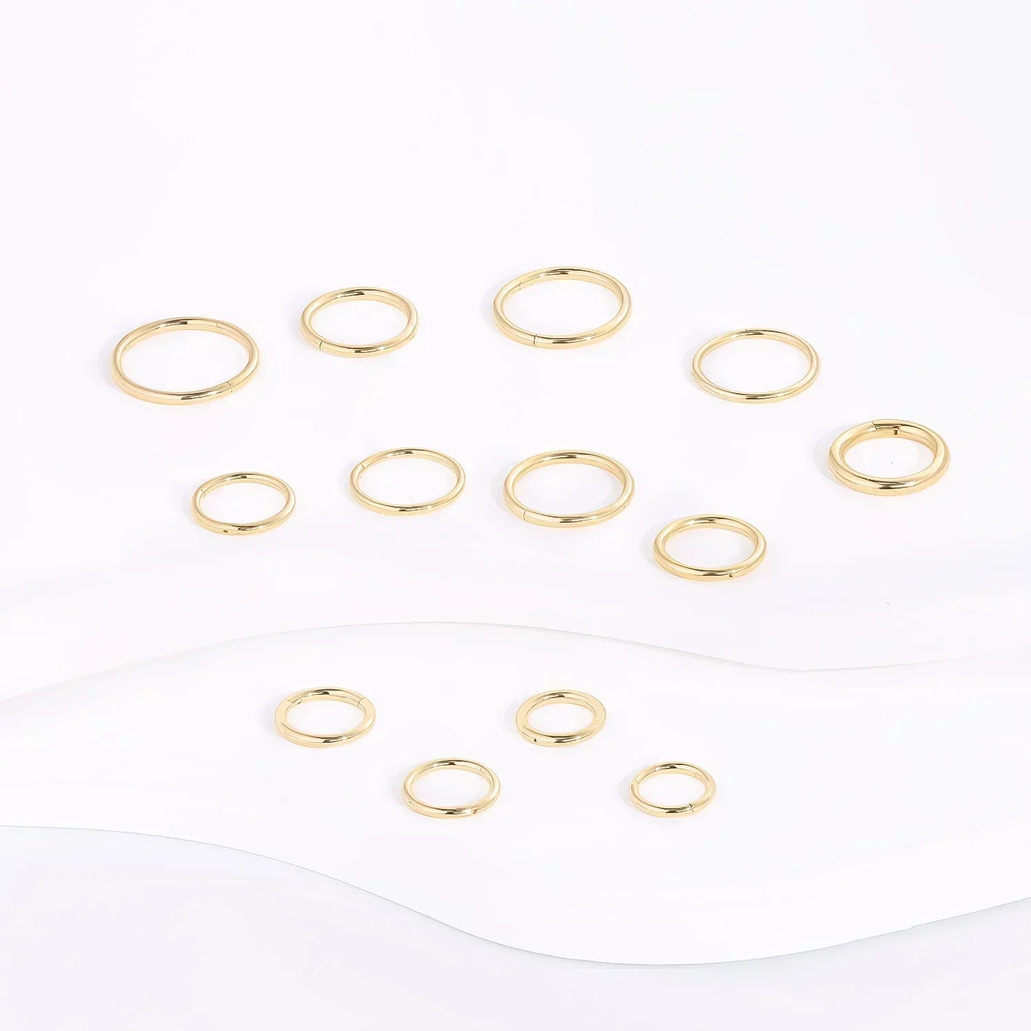 Gold minimalist rings set on white background, Rosary Milano fashion jewelry