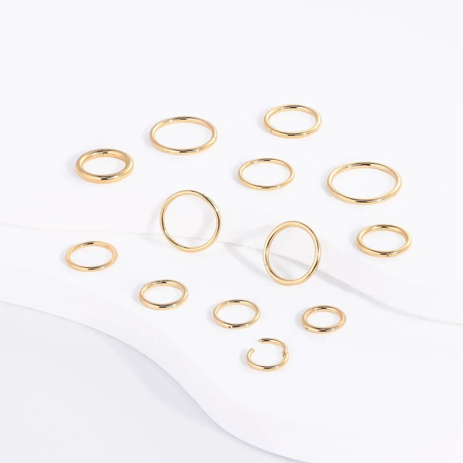 Rosary Milano gold fashion rings set on white background, minimalist jewelry display