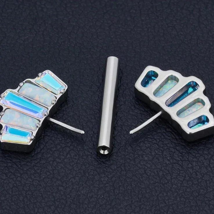 Opal inlay fan-shaped stud earrings and silver bar on black textured surface, Rosary Milano jewelry