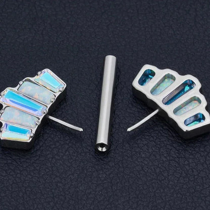 Opal inlay fan-shaped stud earrings and silver bar on black textured surface, Rosary Milano jewelry